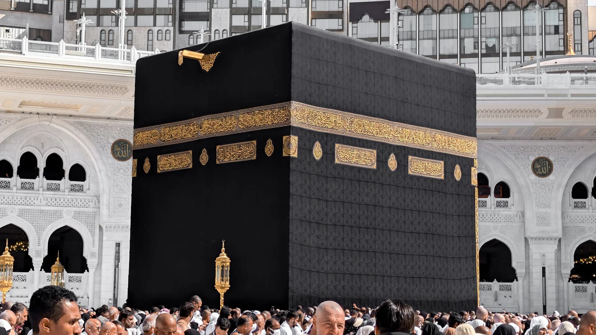 معتمرون بلباس الإحرام أمام الكعبة المشرفة